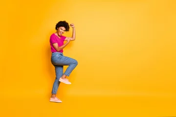 Gordijnen Copyspace photo of charming cheerful cute attractive nice pretty girlfriend wearing jeans denim t-shirt rejoicing with victorious glory isolated over yellow vivid color background © deagreez