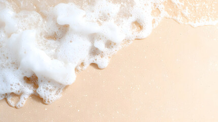 Ocean wave foam on sandy beach; summer vacation background