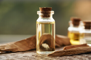 Essential oil in a glass bottle with pieces of white sandalwood