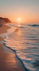 Golden sunrise illuminating sandy beach and gentle waves