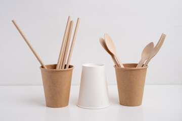 Eco-friendly disposable paper tableware. Paper cup, wooden forks, recycling. Copy space
