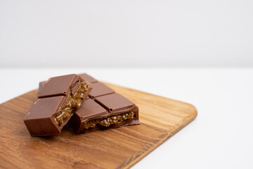 Bar of dark, milk chocolate with filling, Dubai chocolate. Delicious chocolate close-up with nut filling
