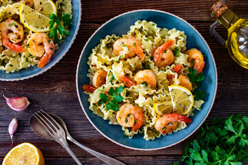 Pasta with seared shrimps, garlic and parsley on wooden table	