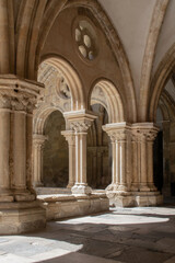 historic interior hallway in cloister church portugal. Empty hall, pillar with carved decorations and arched row. Elegant interior architecture. Religious buildings.
