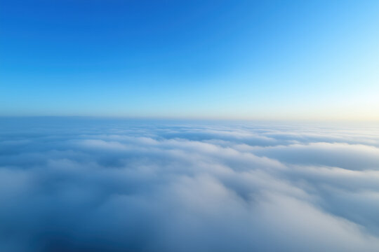 Beautiful aerial view above clouds with blue sky. View from airplane window.