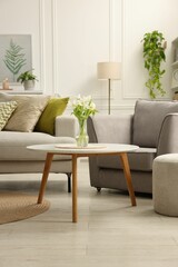 Stylish furniture and houseplants in light living room. Interior design