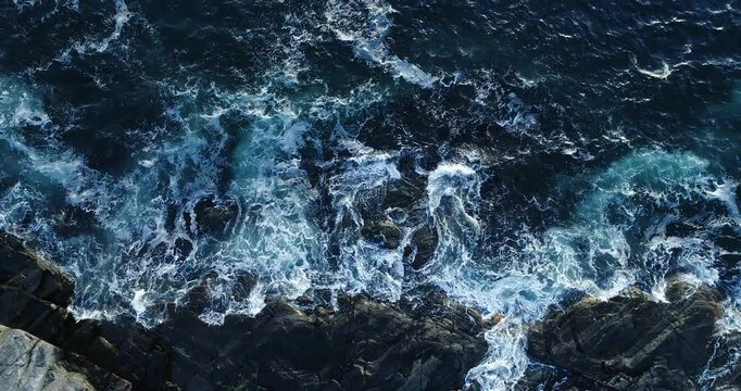 Storm hypnotic powerful waves crashing against rocky coastline in Norway, dramatic ocean scenery, Drone slow-motion footage 4K aerial view