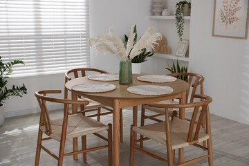 Stylish wooden table with chairs and decor indoors. Interior design