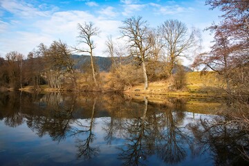 small pond of Dietrichstein in the Southern Austrian province of Carinthia on a cold autumn day with water reflection