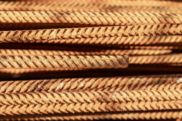 A stack of rusty reinforcement steel on a construction site, lying in the sun. Selective focus.