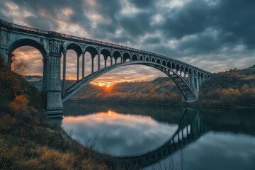 Stunning sunset reflection under a historic arch bridge in a tranquil river setting