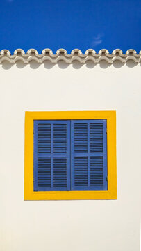 Janela azul com moldura amarela.