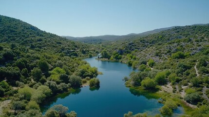 Aerial View of Serene Blue Lake Surrounded by Lush Green Hills