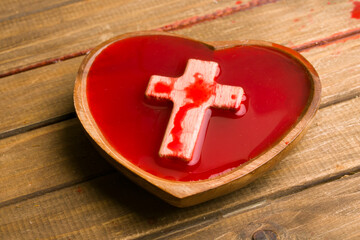 heart shaped bowl of blood and wooden cross