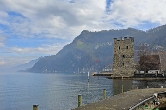 Medieval stone tower Schnitzturm at the lake Lucerne in winter. View of the Alps. Town of Stansstadt, canton of Nidwalden in Switzerland, Europe