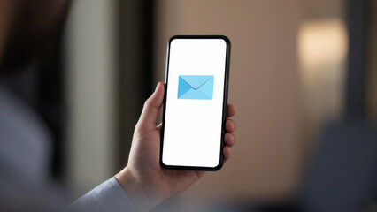  A person is holding a smartphone with an open e-mail application on the screen.....