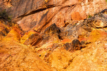 Eroded bauxite rock formation with bright orange colors in an abandoned bauxite mine