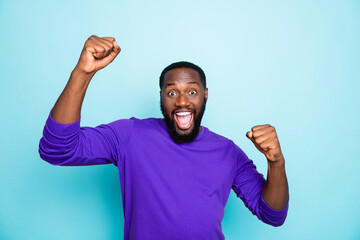 Photo of amazing crazy dark skin guy celebrating lottery winning raising fists yelling triumphing...