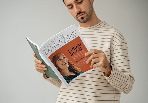 Mockup Of Man Reading Customizable Saddle Stitch Magazine