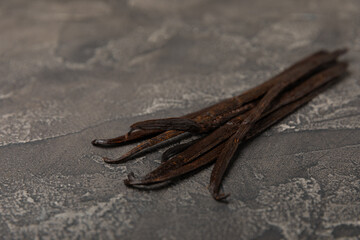Vanilla pods on a textured background. Vanilla flowers and seeds. vanilla stick bean. Aromatic spicy spice for pastries and desserts. Seasoning. Space for text. Copy Space