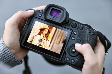 Professional photographer with digital camera outdoors, closeup