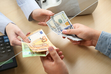 Client exchanging money at wooden table, closeup