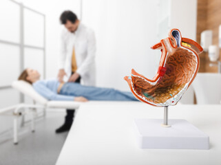 Gastroenterologist consultation, treatment of stomach diseases and ulcers. Doctor palpates woman patient abdomen and examines belly at clinic