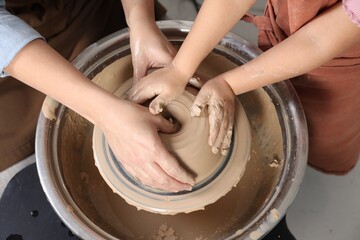 Hobby and craft. Mother with her daughter making pottery indoors, closeup