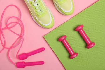 Different sports equipment and sneakers on pink background, flat lay