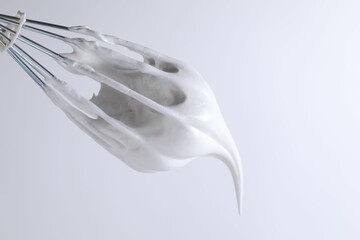 Whisk with whipped cream on white background, closeup