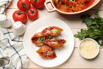 Delicious conchiglie pasta with ricotta cheese, tomato sauce and parsley on wooden table, flat lay