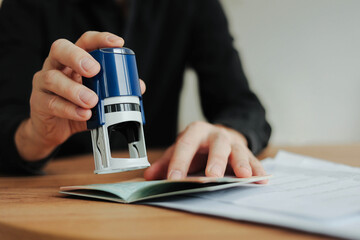 Man border control worker puts a stamp in the passport. Tourism, boarding control. Copy space.