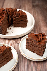 Decadent chocolate cake slices with rich, creamy frosting on rustic plates, perfect for dessert lovers seeking a delightful, indulgent treat that's both moist and flavorful.