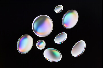 A group of abstract round droplets isolated on black background. Abstract 3d render shape element. Iridescent glass texture.