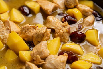 In a frying pan, chelnt is stewed with potatoes, onions, meat, spices and dates