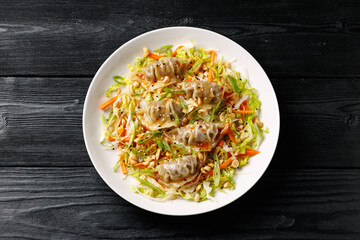 Gyoza Salad or Dumpling Salad with fresh vegetables, nuts and herbs. Asian food