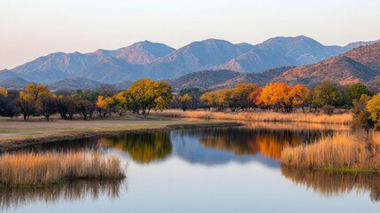 Naklejka premium Autumn Landscape with Golden Trees Reflected in Calm Lake and Mountain Background