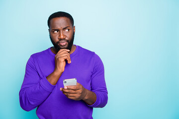 Photo of concentrated man focused on recollecting neccessary facts browsing thorugh telephone he...