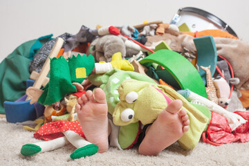 Mountain of toys with a child's feet sticking out from under it