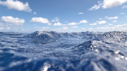 Fototapeta premium Deep blue ocean waves ripple under a bright blue sky with white clouds during a sunny day.