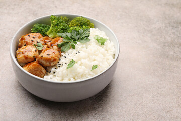 Tasty rice with broccoli, chicken and parsley on grey table, closeup. Space for text