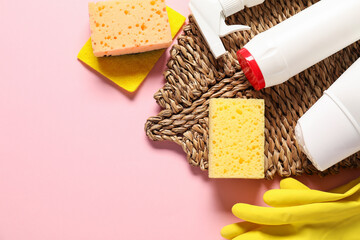 Cleaning products and tools on pink background, flat lay. Space for text