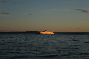 Obraz premium A ferry at sea in the sunset sun.