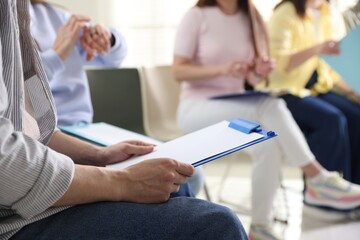 People with clipboards during meeting indoors, closeup