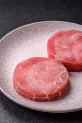 Two fresh slices of raw tuna fillet with spices and herbs