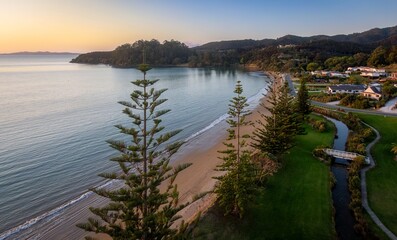 Coastal sunrise view of a tranquil Hihi beach, with homes nestled in the hills. Peaceful morning scene. , Hihi, Northland, NZ