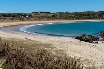 Tranquil beach scene; people relax on the sand, enjoy the turquoise water. Sunny day at a secluded bay. Matai Bay, Karikari Peninsula, Northland, NZ