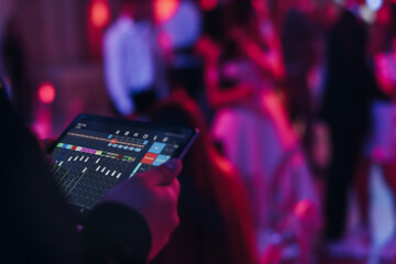 View of lighting technician with tablet, operator controlling sound and light during live event...