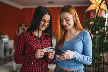 two young high school girls buy online with credit card on cellphone