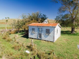 Faded, weathered shed on a rural hillside. Tranquil, rustic scene. Pukenui, Te Kao, Northland, NZ